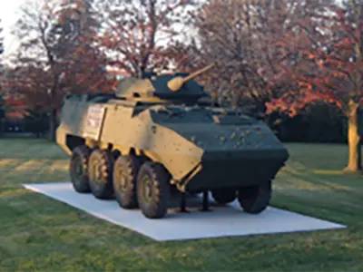 War tank sitting on a grey slab in a green field - LAV (2017 – Afghanistan Conflict) 