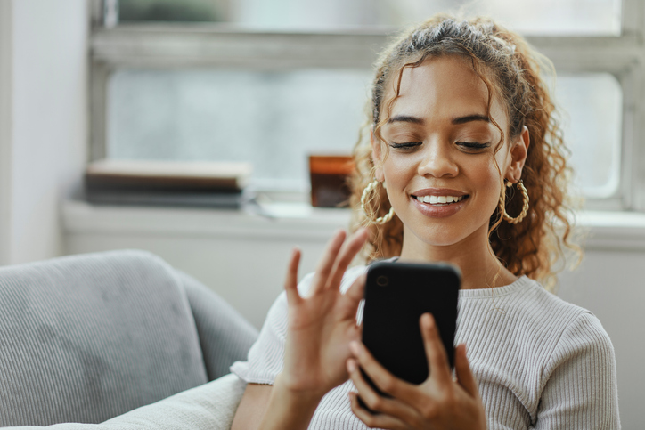 Woman smiling and touching the screen of her phone