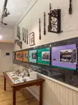 "Historical artifacts in a display case and hung on a wall. Educational posters also hung on the wall."